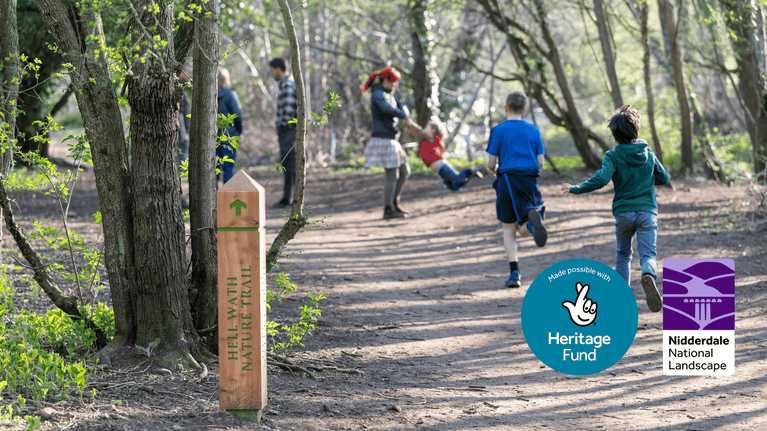 children running past a directional signpost in the Hell Wath local nature reserve